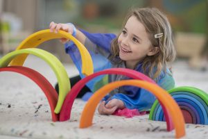 cute-elementary-girl-building-a-rainbow-structure